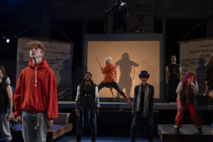 Henry MacDowell (left, orange shirt as “young Robby”) with cast. (Photo by Sabine Lola Stock)